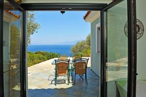 a glass door leading to a patio with a table and chairs at Villa Platanaki in Kerveli