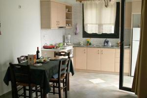 a kitchen with a table and chairs and a kitchen with a sink at Villa Platanaki in Kerveli