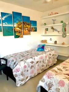 um quarto com uma cama e algumas pinturas na parede em Apto en SAI a metros de la playa - DASH Vacaciones em San Andrés
