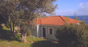 a small house with an orange roof on a hill at Villa Platanaki in Kerveli