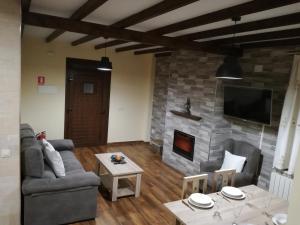 a living room with a couch and a fireplace at Casa Rural Mirador del Valle in Cepeda