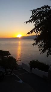 a sunset over a body of water with the sun setting at Villa Platanaki in Kerveli