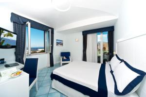 a hotel room with a bed and a view of the ocean at Hotel Villa Durrueli Resort & Spa in Ischia