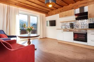 ein Wohnzimmer mit einer Küche mit einem Tisch und einem Sofa in der Unterkunft Apartments Radstadt in Radstadt