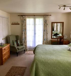 WoodsfordにあるHigh Meadのベッドと椅子と窓のある寝室