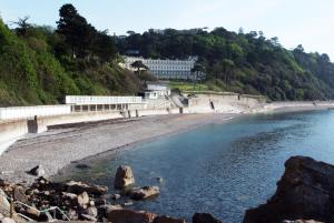 a beach with a large white building on a hill at The Osborne Hotel in Torquay