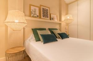 sypialnia z białym łóżkiem z zielonymi poduszkami w obiekcie COMFORT & STYLE IN MADRID!!! 3BD 2BTH+TERRACE w Madrycie