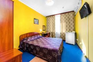 チュメニにあるHotel Filtonの黄色い壁のベッドルーム1室(ベッド1台付)