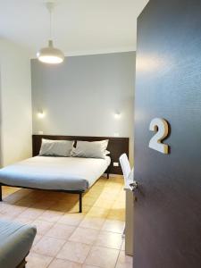 a bedroom with a bed and a door with a number two at Bakirooms in Rome