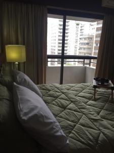 uma cama num quarto de hotel com uma janela em Flat SP - Paulista em São Paulo