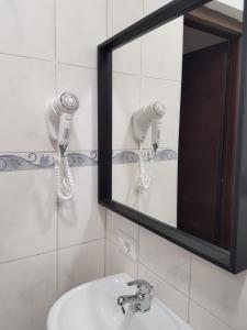 W łazience znajduje się lustro i umywalka. w obiekcie Bakirooms w Rzymie
