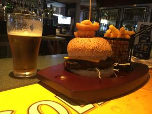 een hamburger en frietjes en een glas bier bij Rosehill Hotel in Sydney