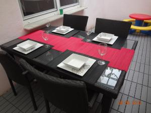 a black table with plates and wine glasses on it at Ferienwohnung am Europapark - klimatisiert in Rust