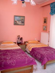 トリカラにある3 Brothers - Διαμέρισμα στο κέντρο των Τρικάλωνのピンクの壁のドミトリールーム ベッド2台