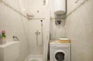 a bathroom with a washing machine and a shower at Apartments Mira - great location in Splitska