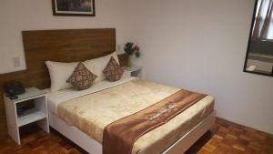 1 dormitorio con 1 cama grande en una habitación en Gervasia Hotel Makati en Manila