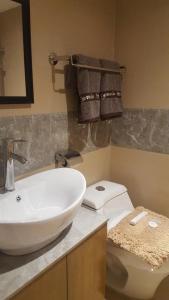 a bathroom with a sink and a toilet at Gervasia Hotel Makati in Manila