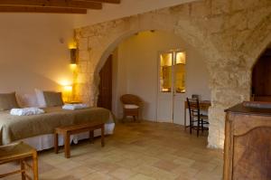 een slaapkamer met een bed en een tafel in een kamer bij Alcaufar Vell Hotel Rural & Restaurant in Sant Lluis