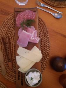 eine Holzplatte mit Käse und eine Schüssel Soße in der Unterkunft Haus Schaaf b&b in Walvis Bay