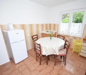 a dining room with a table and a refrigerator at Apartment Andja - 5 m from the beach in Trogir