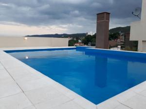 a large blue swimming pool on top of a building at Edificio Hipolito Irigoyen in Villa Carlos Paz