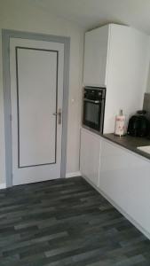 Mazières-en-Gâtineにあるla bouquetiereの白いドアと電子レンジ付きのキッチン