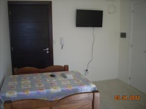 1 dormitorio con 1 cama y TV de pantalla plana en Edificio Hipolito Irigoyen en Villa Carlos Paz