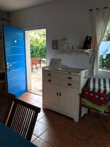 a kitchen with a white cabinet and a blue door at House Ivas with garden in Zambratija