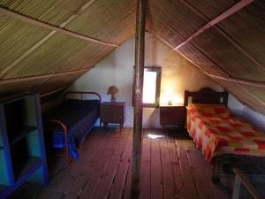 a bedroom with two beds and a window in a tent at La Azurra in Barra de Valizas