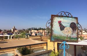 a painting of a rooster on top of a building at Riad Le Coq Berbère in Marrakesh
