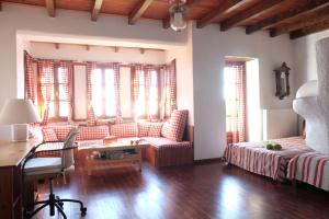 Cette chambre comprend un lit, un bureau et des fenêtres. dans l'établissement Villa Pasithea, à Panteleímon
