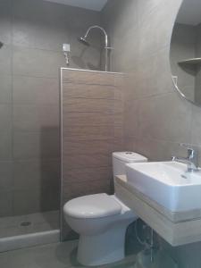 a bathroom with a toilet and a sink and a shower at Byzance Hotel in Skala