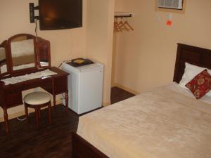 a bedroom with a bed and a desk and a computer at Motel la Maison de Travers in Baie-Sainte-Catherine