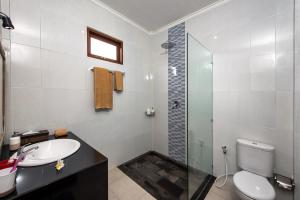 a bathroom with a sink and a toilet and a shower at Griya Private Villa in Ubud