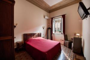 a bedroom with a red bed and a window at B&B Novecento in Palermo