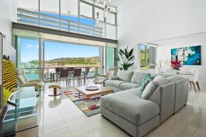 a living room filled with furniture and a large window at Peninsula Airlie Beach in Airlie Beach