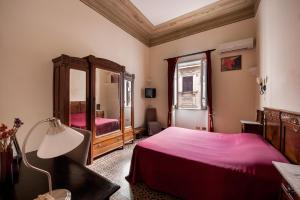 a bedroom with a bed and a large mirror at B&B Novecento in Palermo