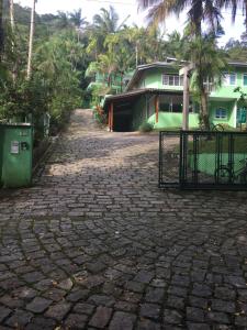 eine steinerne Einfahrt mit einem Tor vor einem Haus in der Unterkunft Marencanto Pousada in Ubatuba