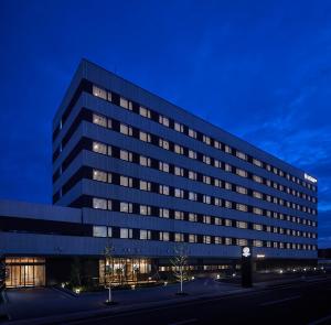 un gran edificio de oficinas con un reloj delante en HATAGO INN Fukushima Hirono, en Hirono