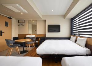 a hotel room with a bed and a table at HATAGO INN Fukushima Hirono in Hirono