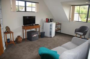 a living room with a couch and a tv at 4B on REARSBY in Christchurch