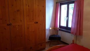 een slaapkamer met een houten kast en een raam bij Barlangia (253 Ho) in Valbella