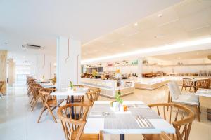 a restaurant with tables and chairs and a kitchen at HARRIS Resort Batam Waterfront in Sekupang