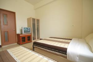 馬公市的住宿－長堤民宿，一间带两张床的卧室和一台电视