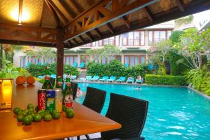 a table with bottles and fruit next to a swimming pool at Ubud Wana Resort in Ubud
