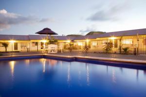 a swimming pool in front of a building at night at Motel Oasis in Gisborne