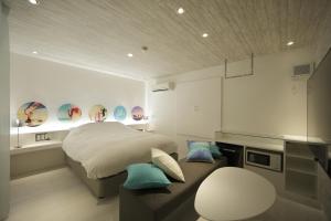 a room with a bed, a table, and a painting on the wall at HOTEL SPARK (Adult Only) in Sendai