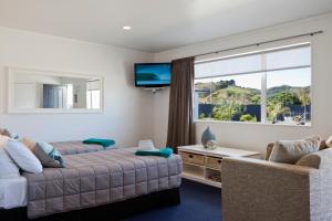 een woonkamer met een bank en een groot raam bij Motel Oasis in Gisborne