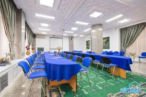 a conference room with blue tables and chairs at Otrar in Almaty