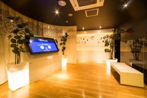 a room with a tv on a wall with plants at Hotel Aqua Color (Adult only) in Fukushima